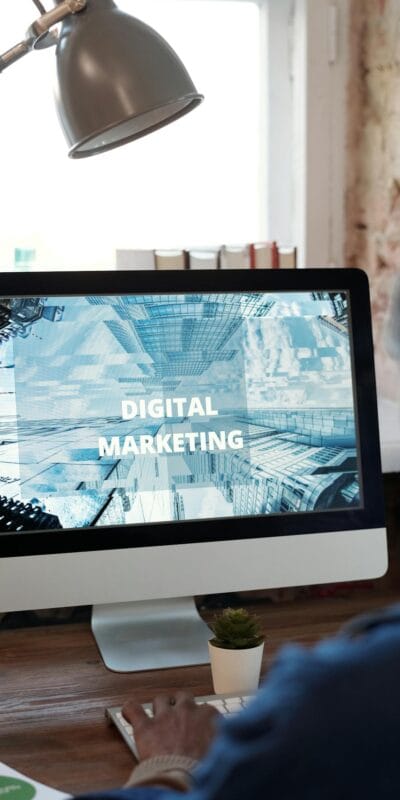 An individual focused on digital marketing on a desktop computer in a cozy workspace.