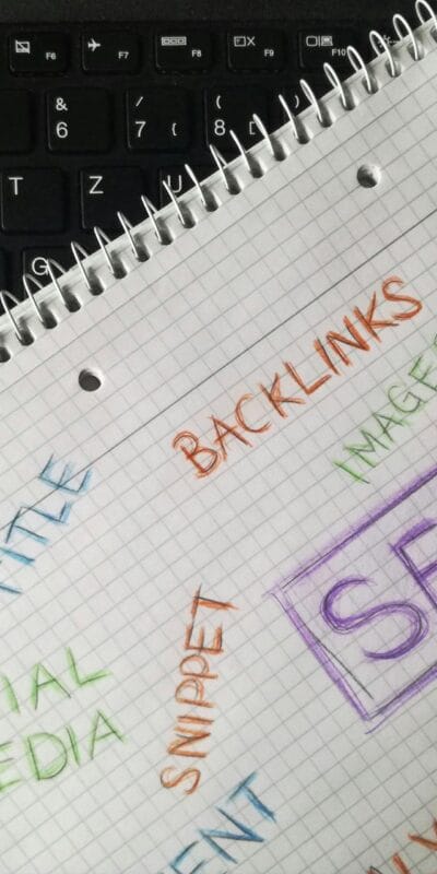 Close-up of notebook with SEO terms and keywords, highlighting digital marketing strategy.