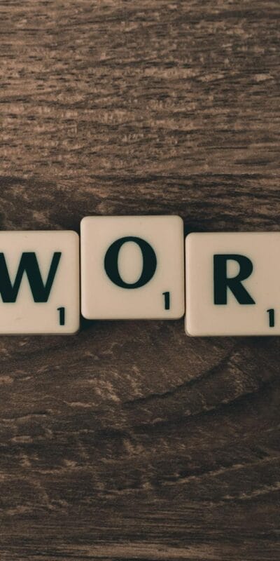 Scrabble tiles spelling 'AdWords' on a wooden surface, symbolizing digital marketing concepts.